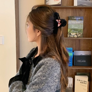 Plush black hair claw clip with red and blue plaid bow for elegant autumn hairstyles