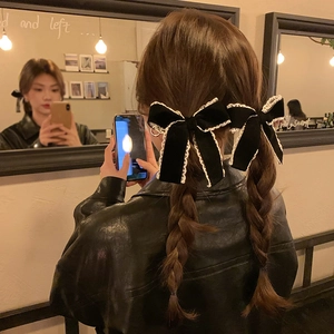 Elegant black velvet hair bows with white lace trim on braided pigtails for women