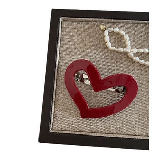 Elegant red heart-shaped acetate hair clip with glossy finish and silver metal spring