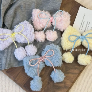 Lot de quatre barrettes à nœuds en peluche aux tons pastel avec pompons sur tricot