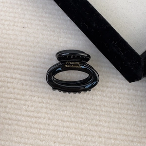 Detail view of handmade black acetate hair claw with gold France lettering inside