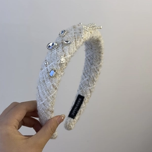 Detail of white tweed headband with pearls, crystals, and silver rose accents