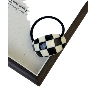 Minimalist checkerboard acetate hair tie with black and white oval resin piece