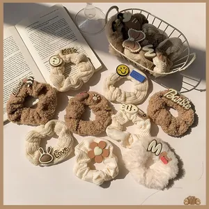 Dettaglio di elastici in peluche color caffè con simpatici orsetti e trame in maglia