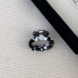 Detail of a handmade tortoise shell pattern acetate hair claw on a knit background