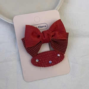 Detailansicht der festlichen roten Haarschleife und Strass-Haarklammer für Mädchen