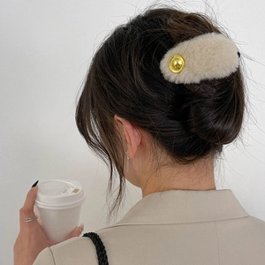 Elegant beige plush banana hair clip for women featuring a gold metallic button accent