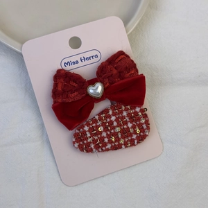 Detail der roten Tweed-Haarspangen mit Herzperle und Pailletten auf Displaykarte