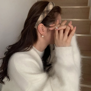 British style yellow plaid headband and pearl earrings worn by a model in a white sweater