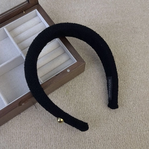 Elegante cerchietto in tweed nero con fiocco asimmetrico e dettaglio di perla dorata