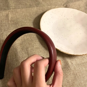 Close-up of burgundy leather headband with crocodile texture and black non-slip lining