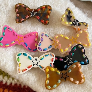 Colorful knitted bow hair clips for girls with star patterns and handmade stitching details