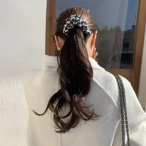 Classic houndstooth hair scrunchie shown on a ponytail for a vintage French style look