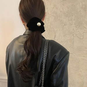 Elegant black velvet hair scrunchie with large white pearl accessory for ponytail style