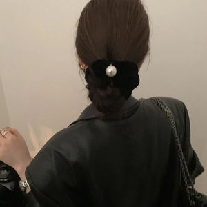 Elegant black velvet bow hair scrunchie with large pearl detail for low bun hairstyle