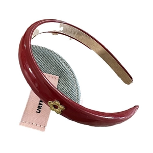 Deep red PU leather headband for women with glossy finish and gold flower detail