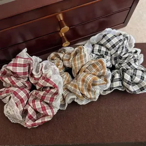 Three-piece French vintage plaid scrunchie set with white lace edges on velvet background