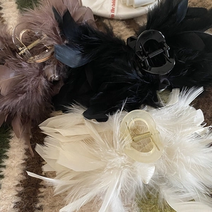 Chic ostrich feather hair claws in brown, black, and beige colors for elegant styling