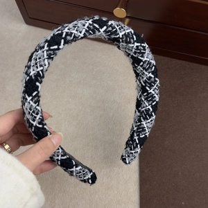Vue détaillée du serre-tête en tweed à carreaux noir et blanc avec texture tissée