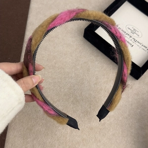 Détail d'un serre-tête torsadé en peluche marron et rose avec dents intérieures antidérapantes