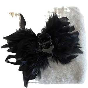 Elegant large black hair claw clip with fluffy ostrich feather decor on grey fabric
