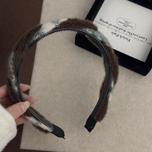 Détail du serre-tête torsadé marron avec dents antidérapantes et texture en peluche