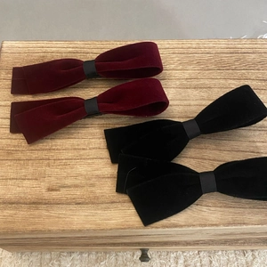 Lot de 4 barrettes à cheveux en velours bordeaux et noir sur un plateau en bois