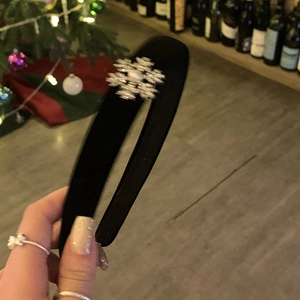 Détail d'un serre-tête en velours avec un flocon en cristal et une perle centrale élégante