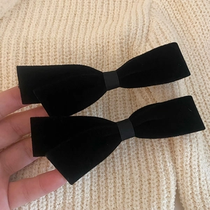 Détails macro d'un lot de barrettes à nœuds en velours noir sur fond en tricot beige