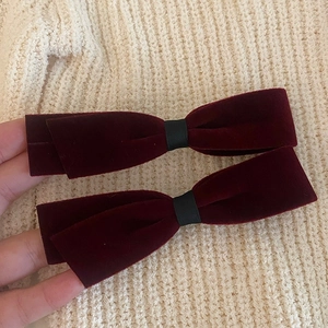 Paire de barrettes à nœuds en velours rouge foncé français sur fond de tricot doux
