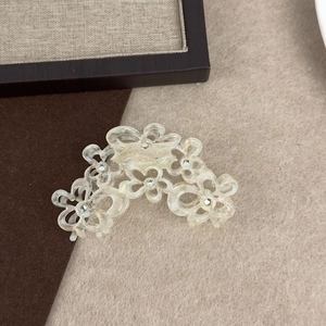Detail der hohlen Blumen-Haarklammer mit funkelnden Strasssteinen und Acetat-Finish