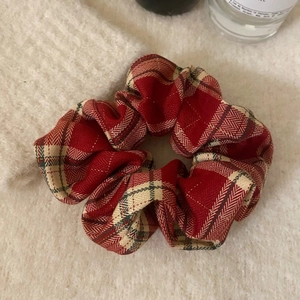 Elastico per capelli in tessuto a quadri rossi vintage su sfondo a maglia morbida