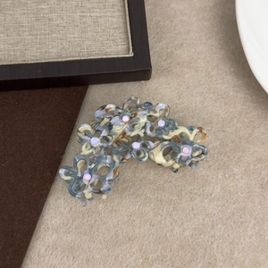 Detail der hohlen floralen Acetat-Haarklammer mit Strass und Perlmutt-Inlay