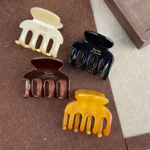 Chic acetate hair claw clips in four colors with gold logo and strong spring grip