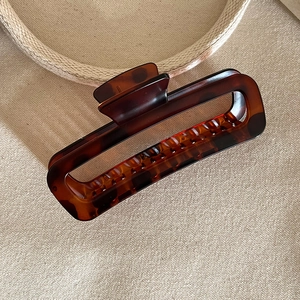 Close-up of tortoise shell pattern hair claw clip with glossy finish and metal spring