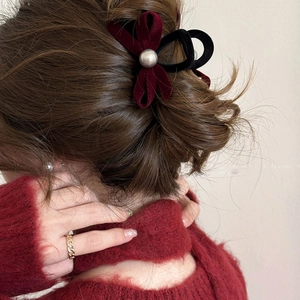 Elegant black and wine red velvet bow hair claw clip with a large pearl accent on woman