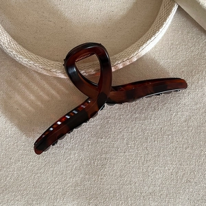 Close-up of amber tortoiseshell hair claw clip with large twist design and strong spring