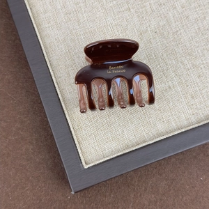 Detailed close-up of dark brown tortoiseshell hair claw with gold Barrette la France logo