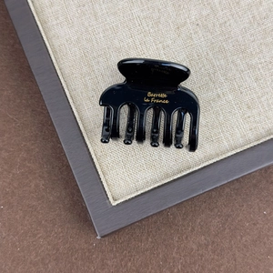 Close-up of black acetate hair claw clip with gold Barrette La France engraving