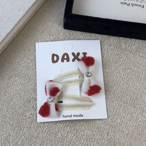 Detail of red and white plush bow hair clips with crystal rhinestone on display card