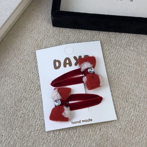 Close-up of red velvet hair clips with plush trim and sparkling center rhinestones
