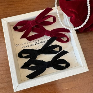 Elegant velvet bow hair clips in wine red and black on a vintage tray with pearls