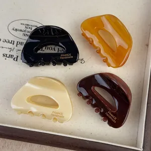 Set of four tortoise shell hair clips in black, amber, and cream with a glossy finish