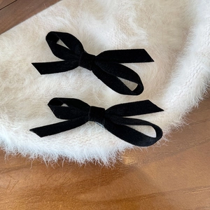 Elegant pair of black velvet bow hair clips for women with luxury texture and classic style