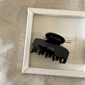 Close-up of black acetate hair claw clip with gold Barrette La France text engraving