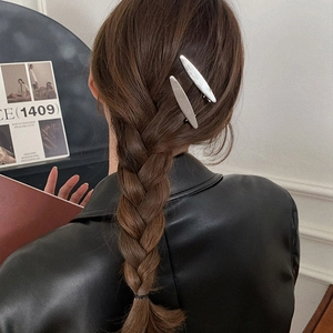 Minimalist matte silver leaf hair clips with brushed metal finish on model's hair