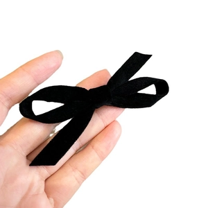 Classic black velvet bow hair clip with long ribbons for an elegant vintage hairstyle