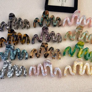 Collection of oversized acetate wave hair claws in marble and tortoiseshell patterns