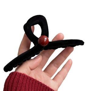 Elegant black velvet claw clip with a red pearl accent for women's winter hairstyling