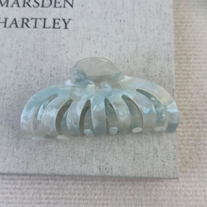 Détail de la grande pince à cheveux en acétate avec motif marbré bleu sur fond gris